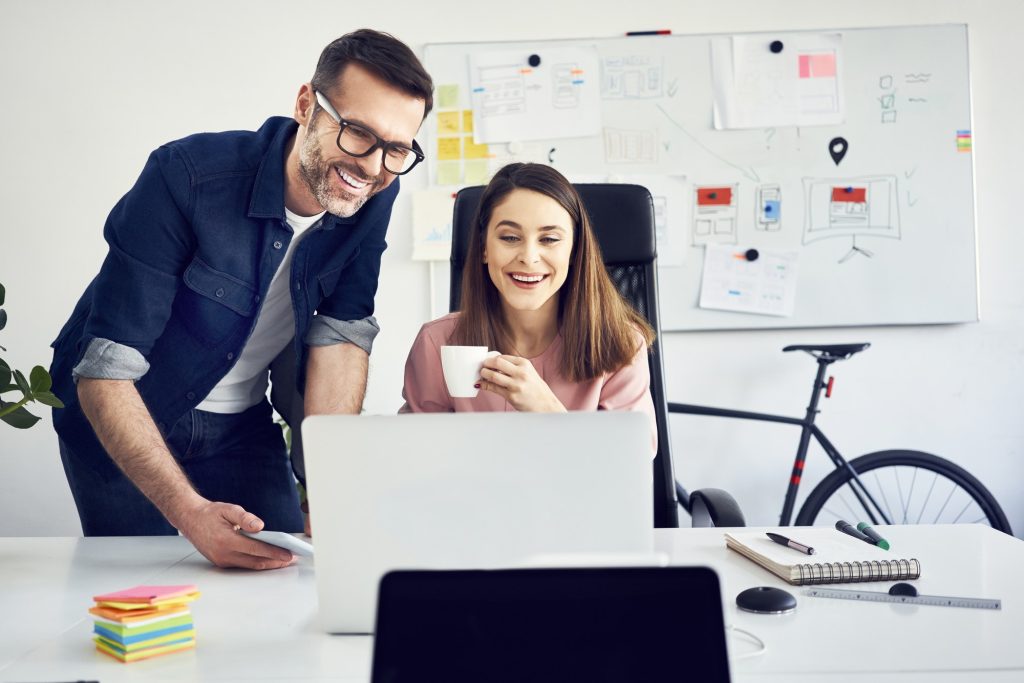 Two colleagues working together on laptop in office